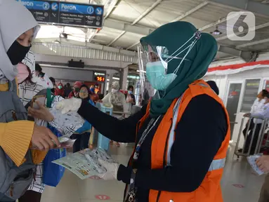 Petugas gabungan membagikan masker kepada calon penumpang  KRL jurusan Jakarta- Bogor di stasiun Tebet, Jakarta, Kamis (27/8/2020). Kegiatan tersebut merupakan rangkaian dari kampanye menggunakan masker di era Adaptasi Kebiasaan Baru untuk menghindari penularan COVID-19. (merdeka.com/Imam Buhori)