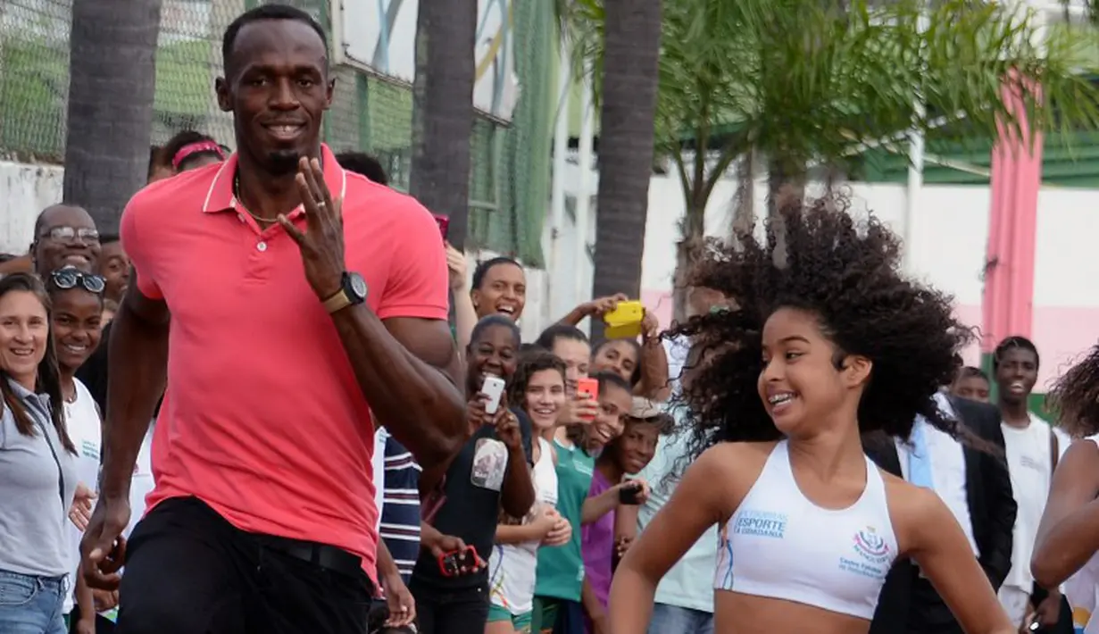 2.	Sprinter Jamaika juara Olimpiade,Usain Bolt, berlomba dengan anak-anak saat mengunjungi kompleks olah raga Mangueira, Rio de Janeiro, Brasil. Jumat (16/4)