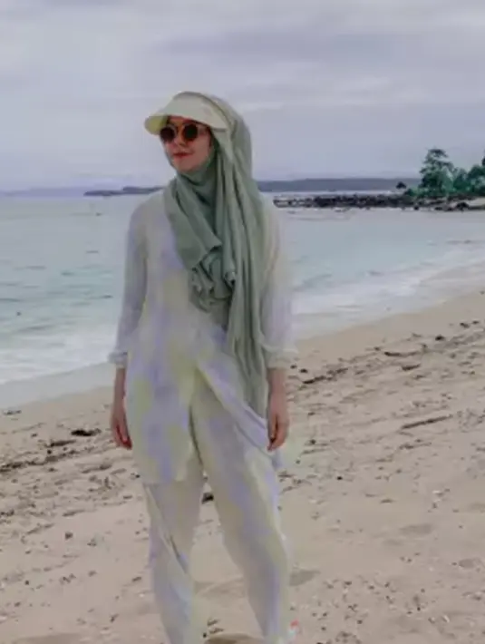 Tak selalu di area pegunungan, namun Risty juga kerap terlihat menikmati momen saat liburan di pantai. Tampil dengan busana santai serta hijab hijau, Risty Tagor juga terlihat menambahkan kacamata hitam serta topi pantainya. (Liputan6.com/IG/@ristytagor)