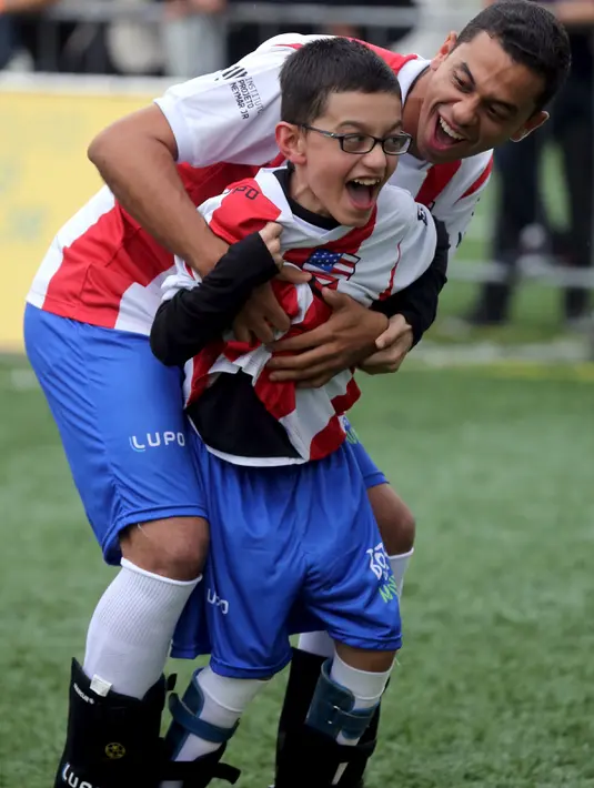 Ekpresi seorang anak berkebutuhan khusus, Gabriel dan pesepakbola Brasil, Gontijo usai mencetak gol saat menghadiri "World Boots" di Neymar Institute, Brasil, 7 Juni 2015.(REUTERS/Paulo Whitaker)