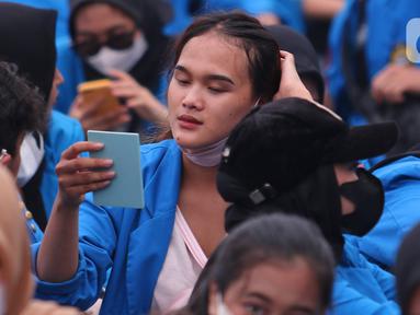 Seorang mahasiswi saat mengikuti aksi di depan Gedung DRI, Jakarta, Kamis (21/4/2022). Parayan Hari Kartini yang jatuh pada 21 april banyak sejumlah perempuan ikut aksi penolakan penundaan pemilu 2024. (Liputan6.com/Angga Yuniar)