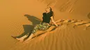Wanita kelahiran tahun 2004 ini tampak menikmati liburannya di Gurun Sahara. Duduk di gurun yang begitu bersih, Aurora tampil santai dengan baju hitam dan celana panjang army. (Liputan6.com/IG/@auroraribero)