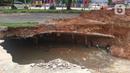 Jalan ambles di ruas Jalan Boulevard, Grand Depok City (GDC), Kota Depok, Jawa Barat, Selasa (13/4/2021). Lubang tanah yang longsor tidak terlalu besar namun tetap terlihat berbahaya jika dibiarkan. (Liputan6.com/Herman Zakharia)
