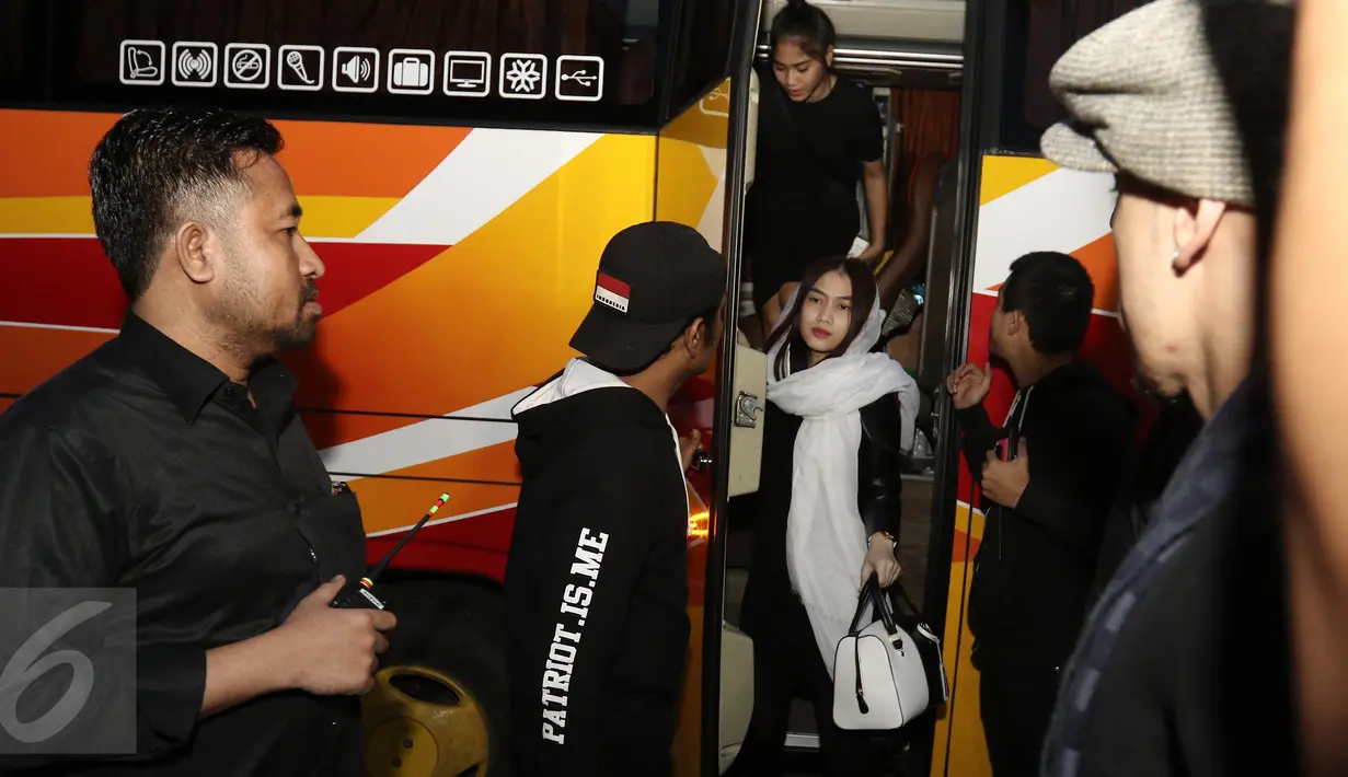 Sejumlah member grup idola JKT48 turun dari bus saat melayat ke kediaman Inao Jiro di Kota Tangerang Selatan, Rabu (22/3). Member sekaligus leader JKT48, Melody juga tampak hadir diantara rombongan. (Liputan6.com/Herman Zakharia)