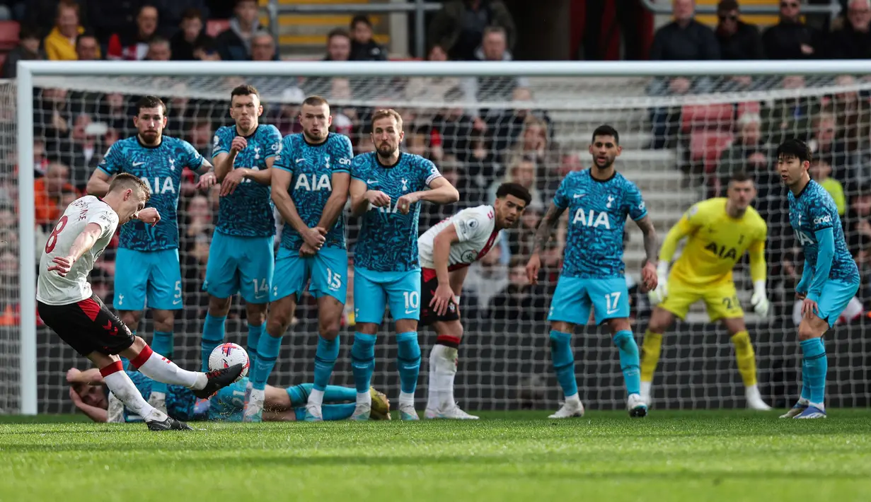 Pemain Tottenham Hotspur, James Ward-Prowse (kiri) melakukan tendangan bebas ke gawang Tottenham Hotspur pada laga pekan ke-28 Liga Inggris 2022/2023 di Stadion St Mary's, Southampton, Minggu (19/03/2023) WIB. Laga berakhir dengan skor imbang 3-3. (AFP/Adrian Dennis)