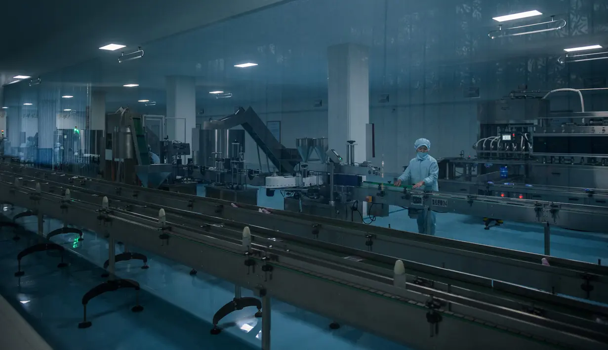 Foto pada 30 November 2018 menunjukkan pekerja berdiri di depan mesin di Pabrik Kosmetik Sinuiju, kota perbatasan Korea Utara dengan China. Pabrik yang didirikan pada 1949 itu adalah basis produksi kosmetik berskala besar di Korea Utara. (Ed JONES/AFP)