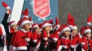 Anak-anak Korea Selatan mengenakan pakaian Santa Claus saat kampanye penggalangan dana untuk orang miskin di depan Istana Gyeongbokgung, Seoul, Jumat (30/11). (Jung Yeon-je/AFP)