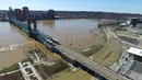 Jembatan Suspensi John A. Roebling membentang di atas sungai Ohio yang meluap dan merendam kota Cincinnati, Ohio serta Covington di Kentucky, Senin (26/2). Sungai Ohio meluap karena hujan lebat berhari-hari. (DroneBase via AP)