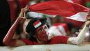 Seorang suporter Timnas Indonesia mengibarkan bendera Merah-Putih saat mendukung tim Garuda melawan Vietnam pada laga Semifinal AFF Cup 2016 di Stadion Pakansari, Bogor, (03/12/2016). (Bola.com/Nicklas Hanoatubun)