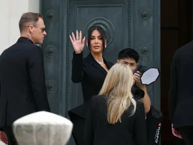 Pesohor asal Amerika Serikat (AS), Kim Kardashian (tengah) melambaikan tangan saat tiba di Pengadilan Assize, Paris, Prancis pada 13 Mei 2025. (Alain JOCARD/AFP)