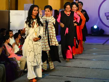 Wanita korban serangan cairan asam berjalan di atas catwalk pada pagelaran busana bertajuk "Beauty Redefined" di Dhaka, Bangladesh, 7 Maret 2017.  Tujuan dari peragaan busana ini adalah menumbuhkan pemahaman warga terhadap kejahatan cairan asam. (STR/AFP)