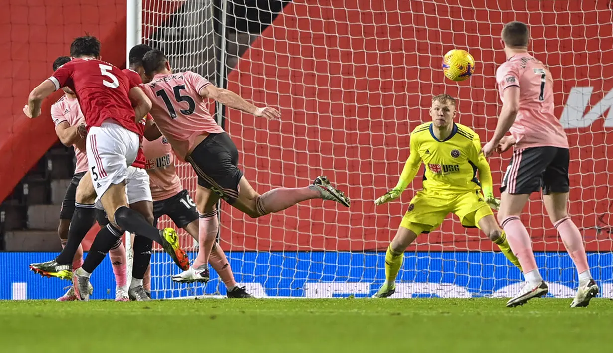 Pemain Manchester United Harry Maguire (kiri) mencetak gol ke gawang Sheffield United pada pertandingan Liga Inggris di Old Trafford, Manchester, Inggris, Rabu (27/1/2021). Sheffield United menang 2-1. (AP Photo/Laurence Griffiths,Pool)