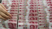 Petugas teller menghitung lembaran 100 yuan di sebuah bank di Lianyungang , China, 11 Agustus 2015. Langkah Bank Sentral China menurunkan nilai tukar yuan terhadap dolar AS langsung membuat pelaku pasar ketakutan. (CHINA OUT AFP PHOTO)