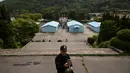 Pengunjung berswafoto dengan latar belakang replika desa perbatasan DMZ Panmunjom di Namyangju, Korea Selatan, Sabtu (5/5). Replika Panmunjom ini dibangun untuk set film thriller-misteri blockbuster 2000, JSA: Joint Security Area. (AFP/Ed JONES)
