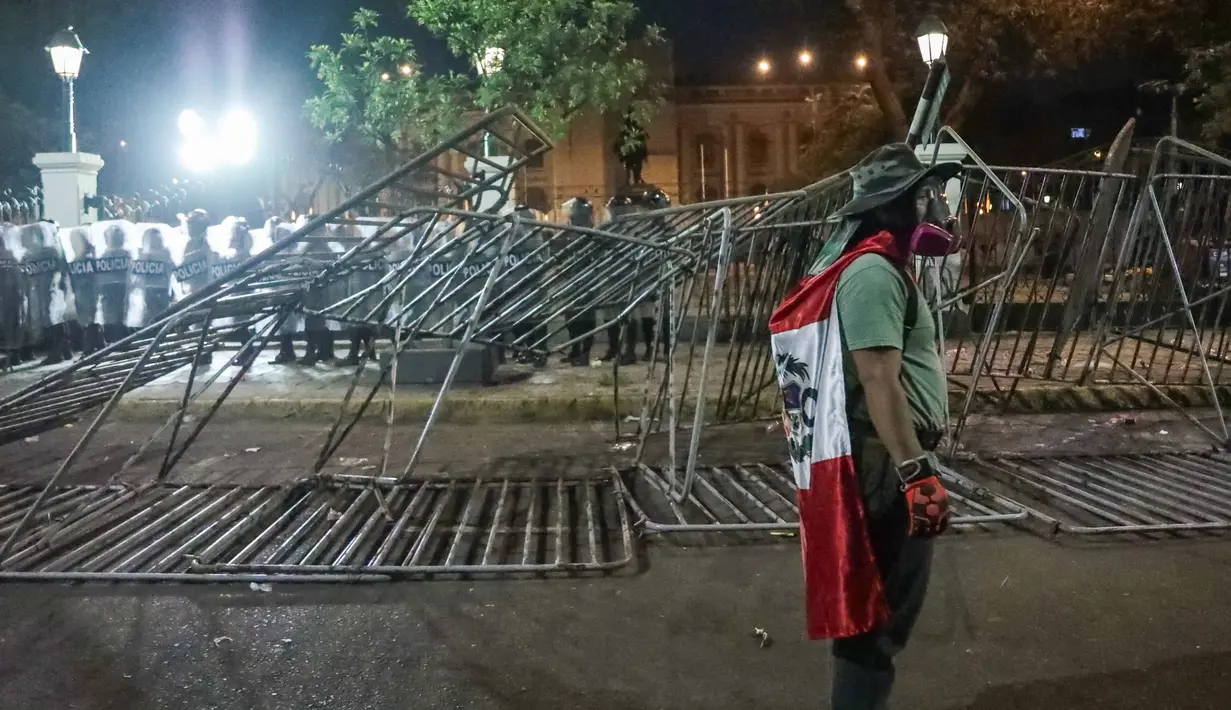 Sebelumnya, ratusan pengunjuk rasa turun ke jalan menuju gedung pemerintahan dengan pengawalan ketat aparat. (CONNIE FRANCE/AFP)