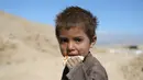 Seorang anak memakan roti di pabrik batu bata di pinggiran Kabul, Afghanistan, Rabu (12/6/2019). Ribuan anak Afghanistan bekerja mencari uang untuk menghidupi keluarga mereka. (AP Photo/Rahmat Gul)