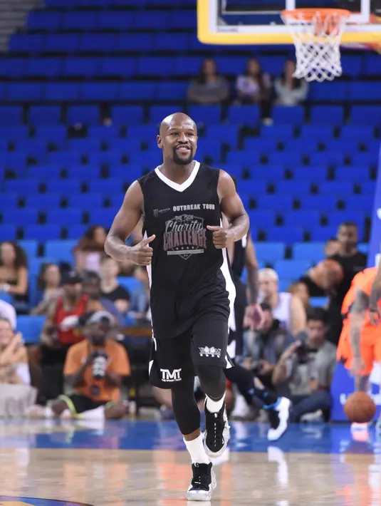 Petinju asal AS, Floyd Mayweather saat bermain basket pada acara amal Monster Energy Outbreak Presents $50K Charity Challenge Celebrity Basketball Game di UCLA's Pauley Pavilion di Westwood, California (17/7). (AFP Photo/Vivien Killilea)