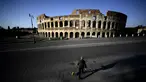 Seorang pria membawa anjingnya jalan-jalan di depan Colosseum, Roma, Italia, 3 April 2020. Menurut Departemen Perlindungan Sipil Italia pada 6 April 2020, jumlah kasus virus corona COVID-19 di negara tersebut menjadi 132.547 infeksi, 16.523 meninggal, dan 22.837 sembuh. (Filippo MONTEFORTE/AFP)