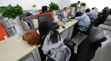 Sejumlah pegawai saat tidur siang di mejanya masing-masing pada jam istirahat di kantornya, di Beijing, China, (21/4). Kegiatan tidur siang ini pemandangan biasa di kalangan pekerja kantoran di China. (REUTERS / Jason Lee)