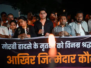 Anggota Kongres Pemuda India ikut serta dalam pawai menyalakan lilin di New Delhi, India, Senin (31/10/2022). Lilin dinyalakan sebagai bentuk penghormatan kepada para korban yang meninggal setelah tragedi jembatan ambruk di seberang Sungai Machchhu. (AFP/Sajjad HUSSAIN)