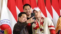 Erick Thohir (kiri) dan&nbsp;Menteri Pemuda dan Olahraga Dito Ariotedjo foto bersama dengan Rizki Juniansyah pada saat di&nbsp;Bandara Internasional Soekarno-Hatta, Tangerang, Selasa (13/8/2024). (Abdul Aziz/Bola.com).