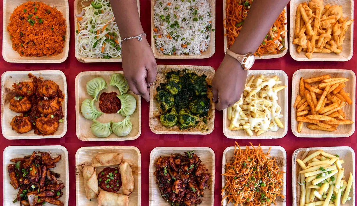 Seorang koki memajang aneka hidangan yang ditawarkan di sebuah kedai makanan dalam festival Bengaluru Aaharotsava, Bangalore, India, Jumat (18/10/2019). Lebih dari 100 kios hadir dalam Bengaluru Aaharotsava. (Manjunath Kiran/AFP)