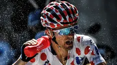 Pemegang kaus polkadot asal Polandia, Rafal Majka, menyemprotkan air ke wajahnya saat beraksi dalam Etape 17 Tour de France berjarak 184,5 km antara Berne dan Finhaut-Emosson, Prancis (20/7/2016). (AFP/Jeff Pachoud)