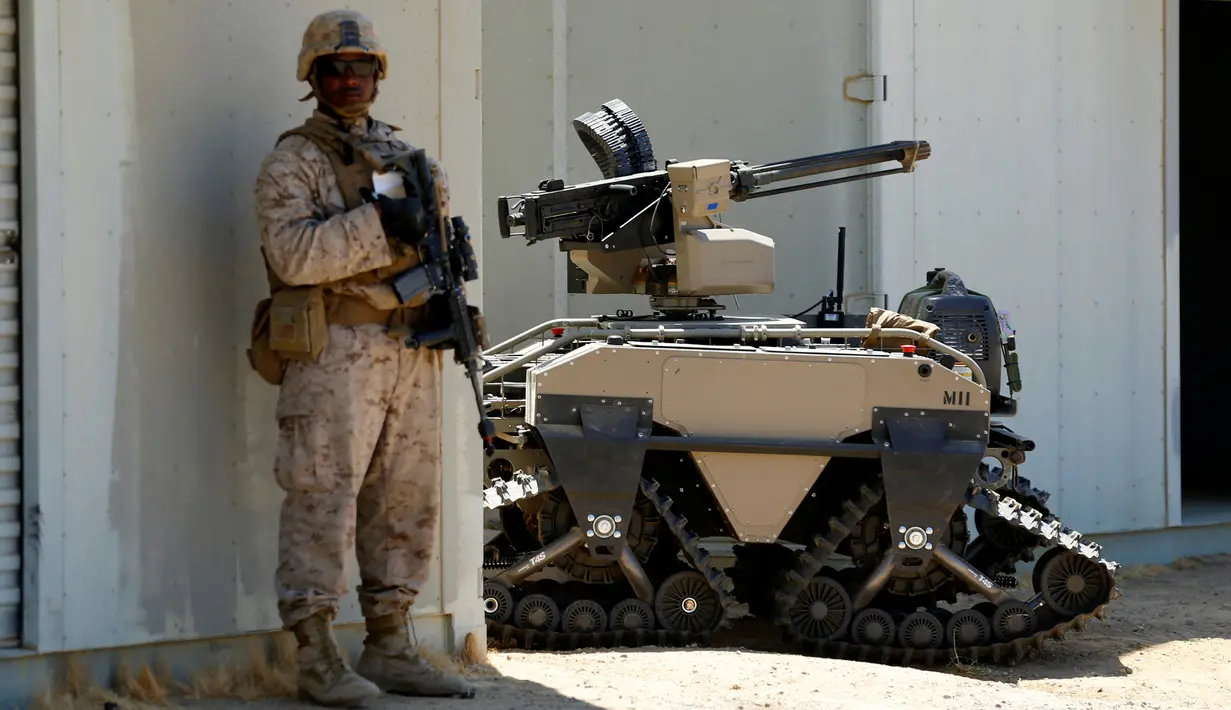 Tentara AS berdiri disamping Multi-Utilitas Tactical Transport (MUTT) saat latihan militer Rim Pasifik (RIMPAC) 2016 di Camp Pendleton, AS (13/7). Alat yang digunakan untuk patroli militer ini mempunyai teknologi canggih. (REUTERS / Mike Blake)