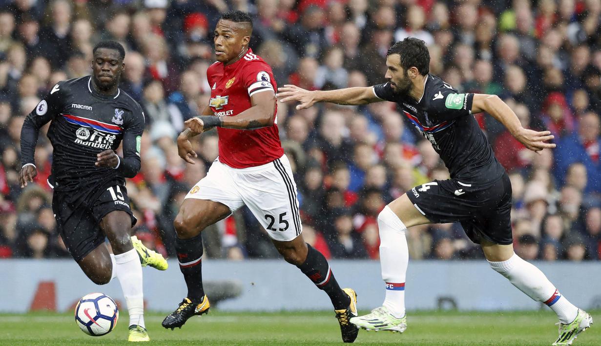 Bek Manchester United, Antonio Valencia, berusaha melewati gelandang Crystal Palace, Luka Milivojevic, pada laga Premier League di Stadion Old Trafford, Manchester, Sabtu (30/9/2017). MU menang 4-0 atas Palace. (AP/Martin Rickett)