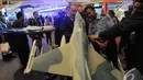 Para pengunjung melihat miniatur sebuah pesawat tempur di Indo Defence 2014, JIExpo Kemayoran, Jakarta, Rabu (5/11/2014)(Liputan6.com/Herman Zakharia)