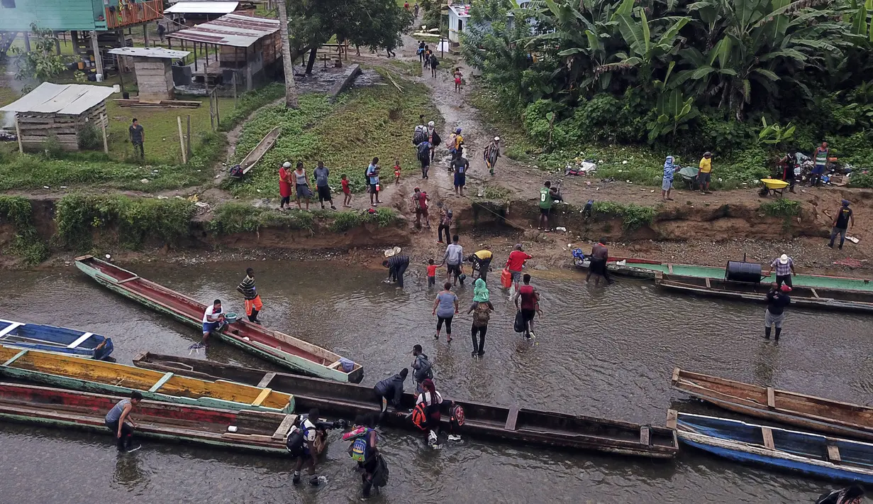 Sekelompok imigran tiba melalui Sungai Tuquesa di Desa Bajo Chiquito, Provinsi Darien, Panama, 22 Agustus 2021. Panama dan Kolombia mencapai kesepakatan untuk mengendalikan banjir imigran yang melintasi perbatasan bersama ke Amerika Serikat. (Ivan PISARENKO/AFP)