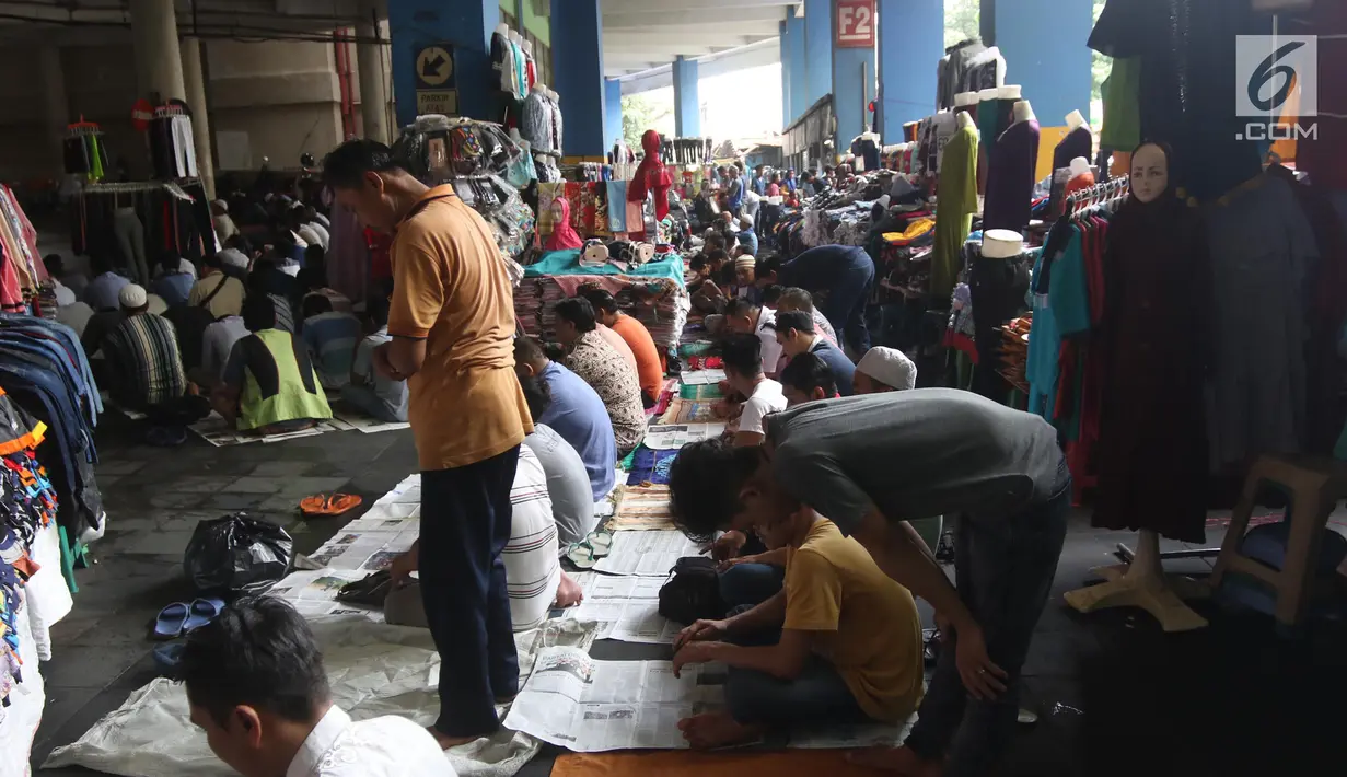 Ramadan di antara pakaian yang dijajakan di Pasar Tanah Abang, Jakarta, Jumat (25/5). Pedagang dan pembeli membaur Salat di lorong kios, selasar, bahkan lorong toilet. (Liputan6.com/Arya Manggala)