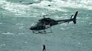 Erendira Wallenda melakukan aksi akrobatik di atas air terjun Niagara, New York, Kamis (15/6). Erendira ditambatkan ke lingkaran besi yang dikaitkan pada helikopter yang terbang 91 meter di atas permukaan air. (Nathan Denette/The Canadian Press via AP)
