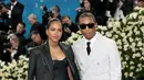 Helen Lasichanh istri Pharell William mengenakan Louis Vuitton, dari jaket kulit senada dengan jumpsuit pantless dipadukan stocking hitam motif LV. [dok. Louis Vuitton]