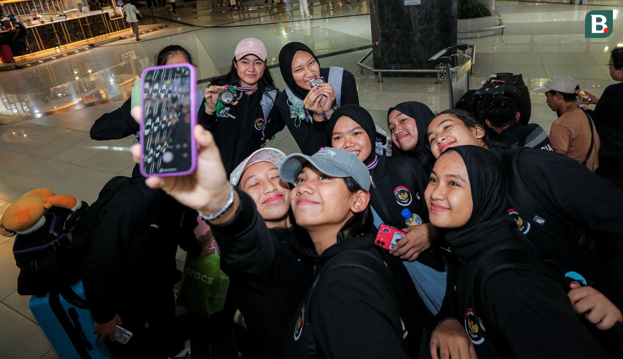 <p>Para pemain Timnas voli putri Indonesia U-18 berswafoto dalam acara penyambutan oleh pengurus PBVSI di Terminal 3 Bandara Soekarno Hatta, Tangerang, Jumat (14/6/2024) usai menempati peringkat kedua pada turnamen bola voli putri Princess Cup 2024. (Bola.com/Bagaskara Lazuardi)</p>
<p>&nbsp;</p>