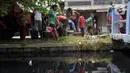 Sejumlah warga mengambil air bersih di kawasan Karangbahagia, Kabupaten Bekasi, Jawa Barat, Selasa (7/9/2021). Pemerintah Kabupaten Bekasi mendistribusikan air bersih kepada warga yang tinggal di pinggiran Kali Cilemahabang. (Liputan6.com/Herman Zakharia)