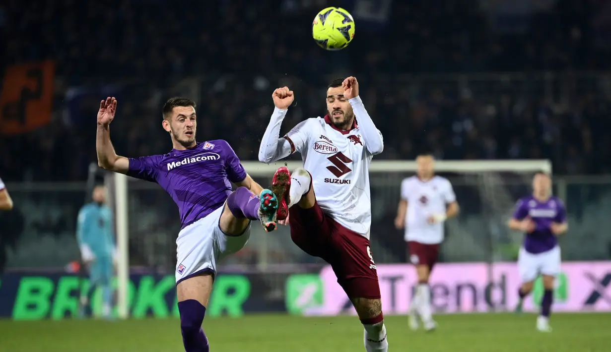 Pemain Fiorentina Aleksa Terzic (kiri) dan berebut bola dengan pemain Torino Antonio Sanabria pada pertandingan sepak bola perempat final Coppa Italia di Stadion Artemio Franchi, Florence, Italia, 1 Februari 2023. Fiorentina mengalahkan Torino dengan skor 2-1 dan berhasil melaju ke babak semifinal Coppa Italia. (Massimo Paolone/LaPresse via AP)