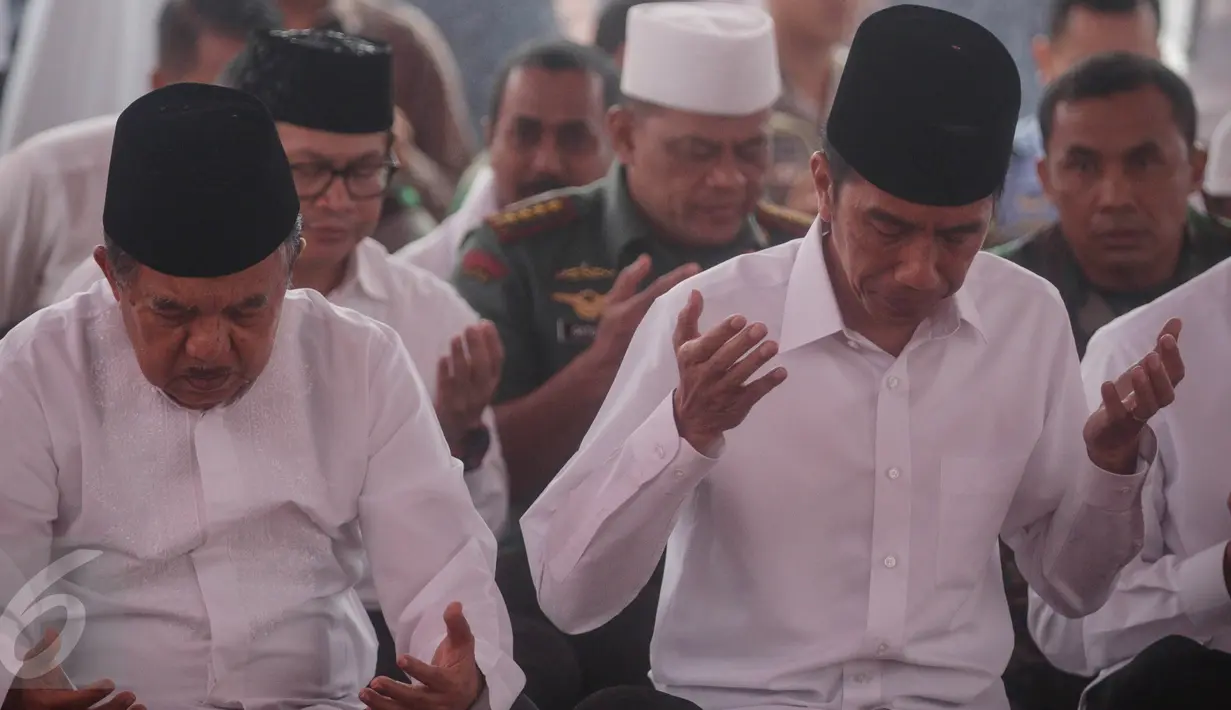 Presiden Joko Widodo dan Wakil Presiden Jusuf Kalla berdoa saat melaksanakan salat Jumat bersama dalam Aksi Bela Islam Jilid 3 di Monumen Nasional, Jakarta, Jumat (2/12). (Liputan6.com/Faizal Fanani)