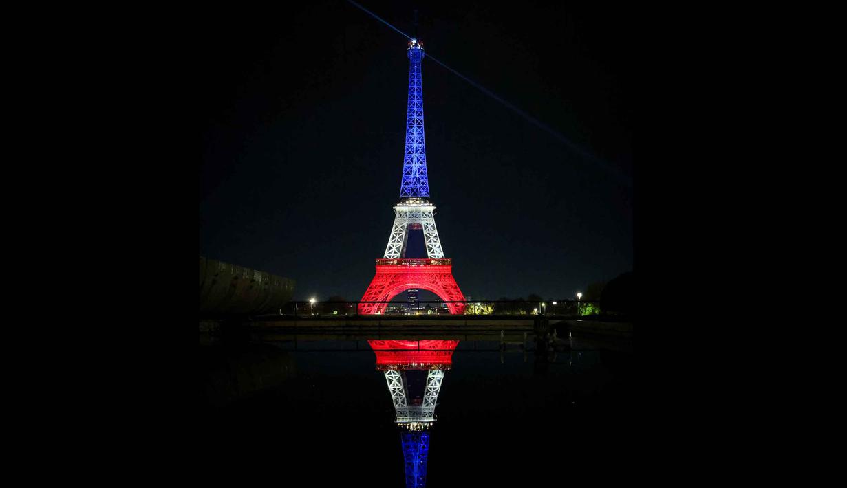 Untuk menandai satu dekade tragedi tersebut, berbagai upacara peringatan diselenggarakan di ibu kota. Tampak sebuah foto memperlihatkan Menara Eiffel yang diterangi dengan warna bendera nasional Prancis saat peringatan ke-10 serangan teroris Paris yang terjadi pada 2015, di Paris, pada 12 November 2025. (Ludovic MARIN/AFP)