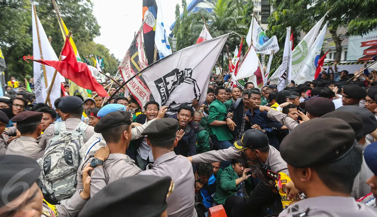 Suasana bentrokan antara polisi dan mahasiswa BEM Se-Jabodetabek di depan Istana Negara, Kamis (12/1). Dalam aksinya mereka menuntut Presiden Jokowi-JK untuk membuat kebijakan yang pro terhadap rakyat. (Liputan6.com/Faizal Fanani)
