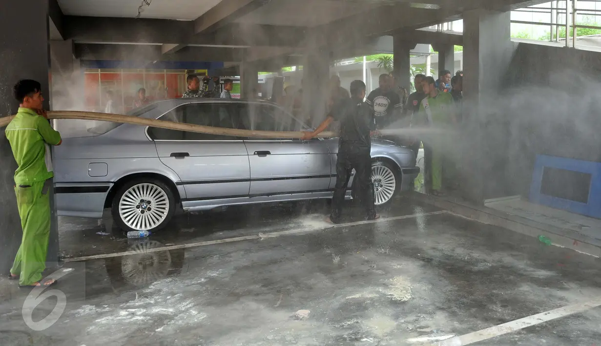Petugas pemadam kebakaran melakukan pendinginan di lokasi kebakaran di SPBU Abdul Muis, Jakarta, Senin (12/9). Kebakaran tersebut diduga terjadi akibat korsleting pada salah satu ruangan hingga membakar kompresor. (Liputan6.com/Gempur M Surya)