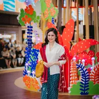 Tissa Biani tampil chic dengan kebaya klasik putih, kain bernuansa hijau kebiruan, dan selendang merah yang kontras namun serasi. [Foto: Instagram/tissabiani]