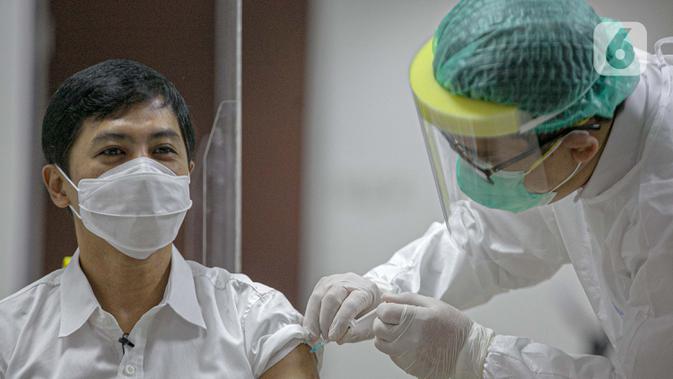 Wakil Menteri Kesehatan Dante Saksono Harbuwono menjalani vaksinasi virus corona COVID-19 di RSCM, Jakarta, Kamis (14/1/2021). Menteri Kesehatan Budi Gunadi Sadikin menuturkan, tahap awal program vaksinasi COVID-19 akan menyasar tenaga kesehatan. (Liputan6.com/Faizal Fanani)