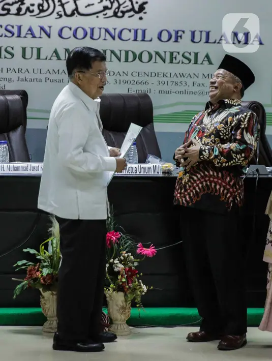 Ketua Dewan Masjid Indonesia Jusuf Kalla dan Wakil Ketum MUI Muhyiddin Junaidi berbincang usai rapat untuk mengeluarkan fatwa di Jakarta, Selasa (17/3/2020). MUI mengeluarkan Fatwa Nomor 14 Tahun 2020 tentang Penyelenggaraan Ibadah dalam Situasi Terjadi Wabah Covid-19. (Liputan6.com/Faizal Fanani)