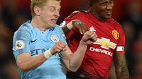 Duel udara gelandang Manchester City, Oleksandr Zinchenko dengan bek Inggris Manchester United, Ashley Young dalam laga lanjutan Liga Inggris di Stadion Old Trafford, Rabu (24/4). Manchester City berhasil membungkam rival sekota Manchester United dengan dua gol tanpa balas. (Oli SCARFF / AFP)