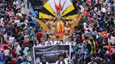 Peserta pawai perayaan Hari Batik Nasional berusaha menembus kerumunan warga saat Hari Bebas Kendaraan di kawasan Bundaran HI, Jakarta, Minggu (1/10). Parade Batik Nusantara ini perayaan Hari Batik Nasional 2 Oktober. (Liputan6.com/Helmi Fithriansyah)