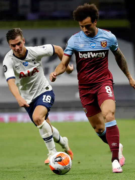 Gelandang West Ham United, Felipe Anderson menggiring bola dari kejaran gelandang Tottenham Hotspur, Giovani Lo Celso pada pertandingan lanjutan Liga Inggris di Stadion Tottenham Hotspur di London (23/6/2020). Tottenham menang 2-0 atas West Ham. (AFP/Pool/Kirsty Wigglesworth)