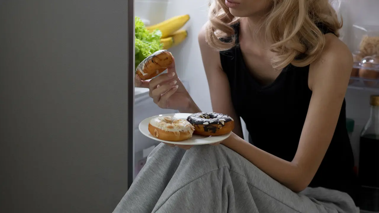 wanita diet duduk di depan kulkas