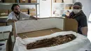 Veronica Silva memperlihatkan salah satu mumi tertua di National Museum of Natural History, Chile (16/12). Para peneliti Chile juga meminta mumi ini dimasukan ke dalam daftar warisan dunia sebagai mumi paling tua di dunia. (AFP PHOTO/Martin Bernetti)