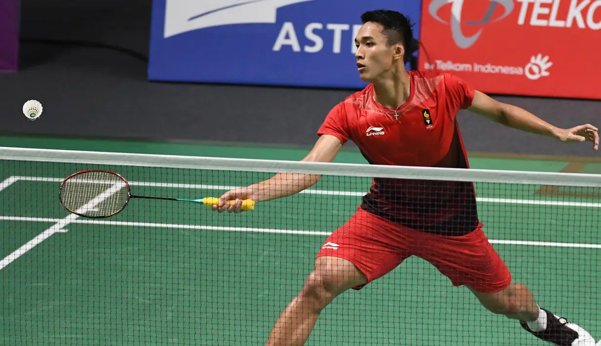 Pebulu tangkis Indonesia, Jonatan Christie mengembalikan kok saat bertanding melawan Kenta Nishimoto asal Jepang dalam semifinal tunggal putra Asian Games 2018 di Jakarta, Senin (27/8). Jonatan melaju ke final. (SONNY TUMBELAKA/AFP)